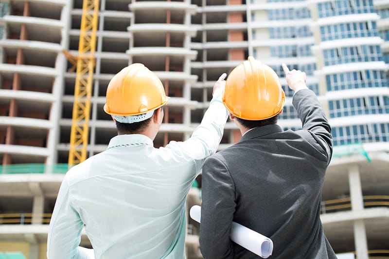 Engineers pointing towards a building