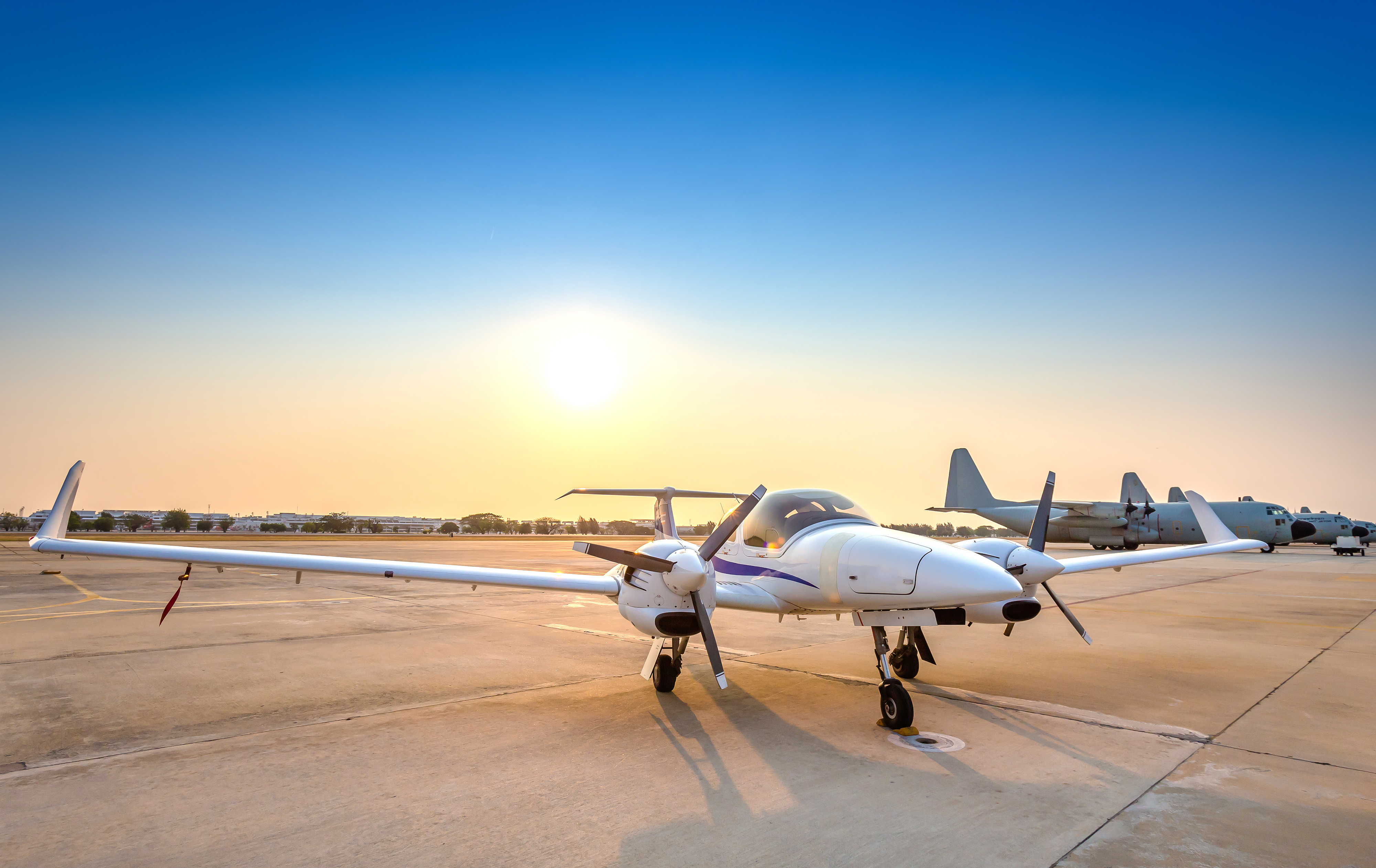 airplane sitting on tarmac in sunset