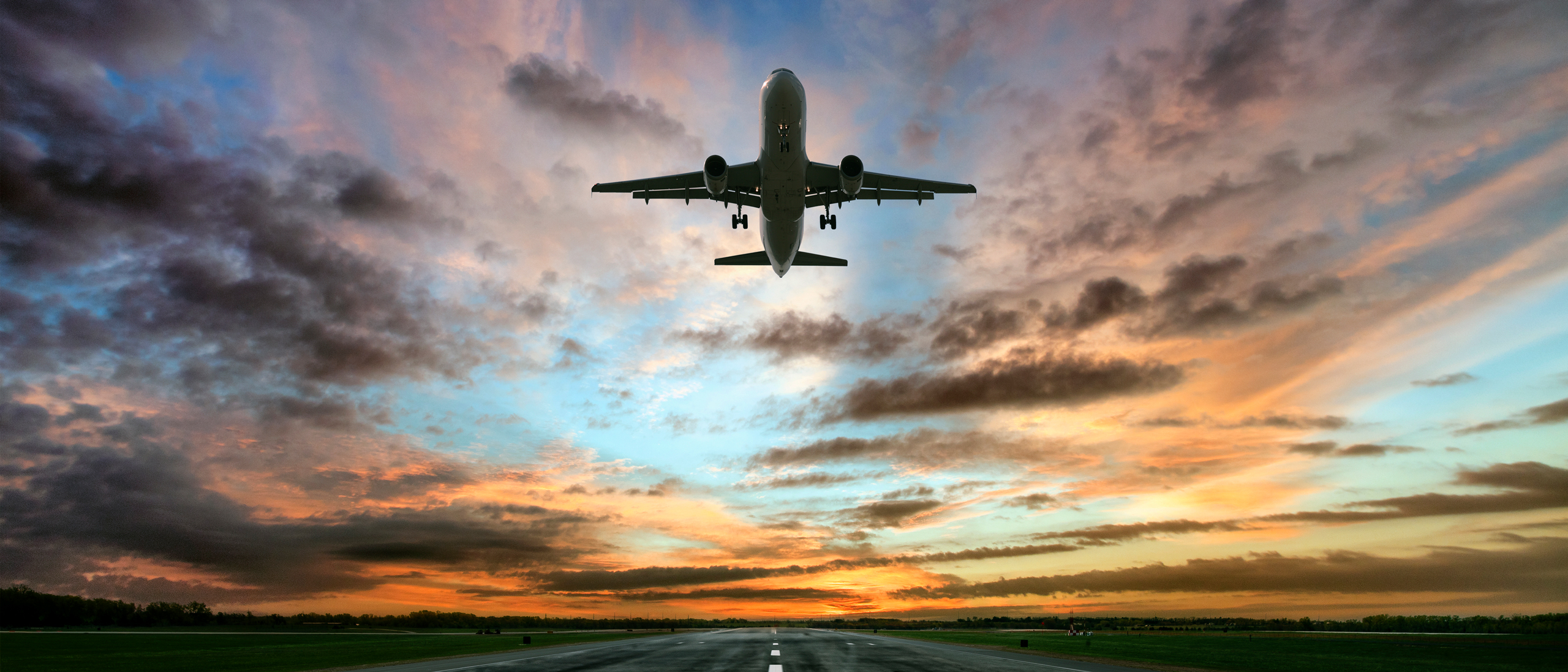 Airplane taking off at sunrise