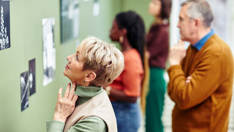 People looking at art on a wall