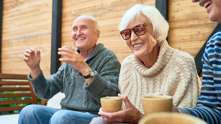 people sitting outside drinking coffee and laughing