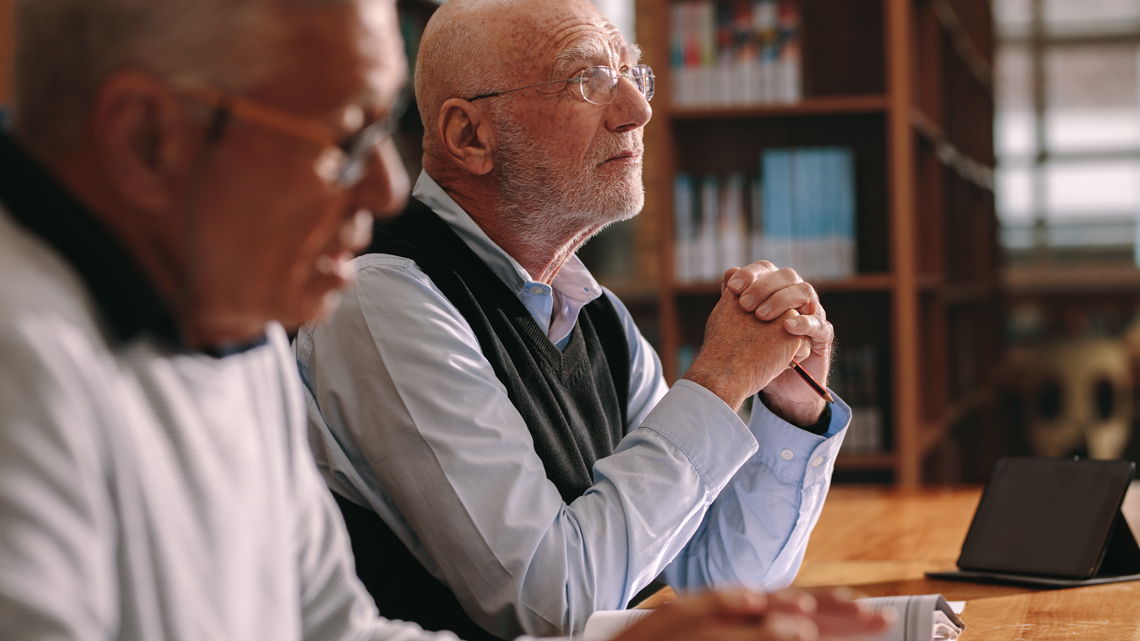 two attendees listening to a presentation